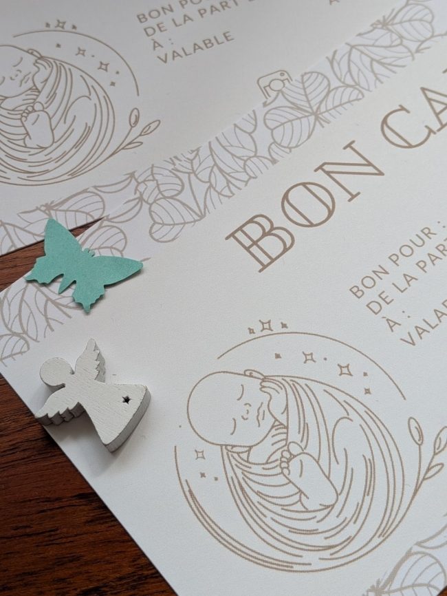 Carte cadeau Parenthèse Bien Naître, posée avec un ange en bois et un papillon
